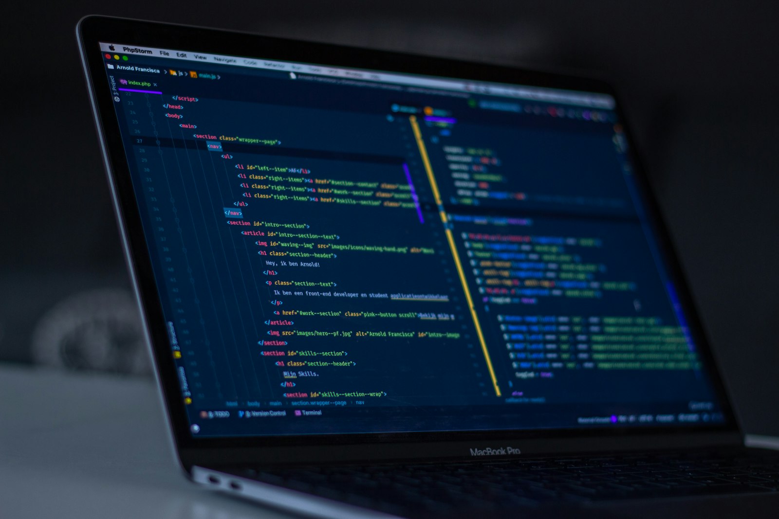Code on a laptop screen in a dark workspace
